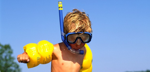 Barn med cyklop, snorkel och gula armpuffar