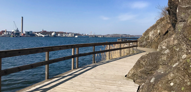 Gångväg med staket vid vatten.