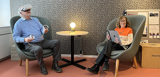 Två seniorer som hanterar VR-glasögon och surfplatta
