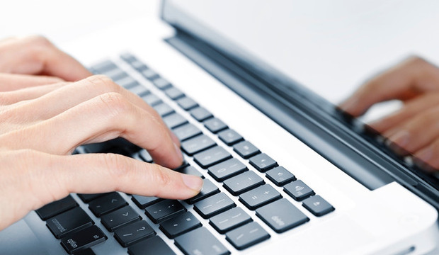 Händer skriver på en laptop.