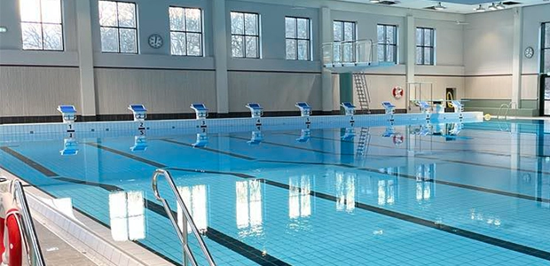 Bassäng med blått vatten, svikt och trampolin.