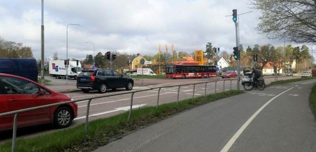Gång- och cykelväg, bilar och körbana i bakgrunden.