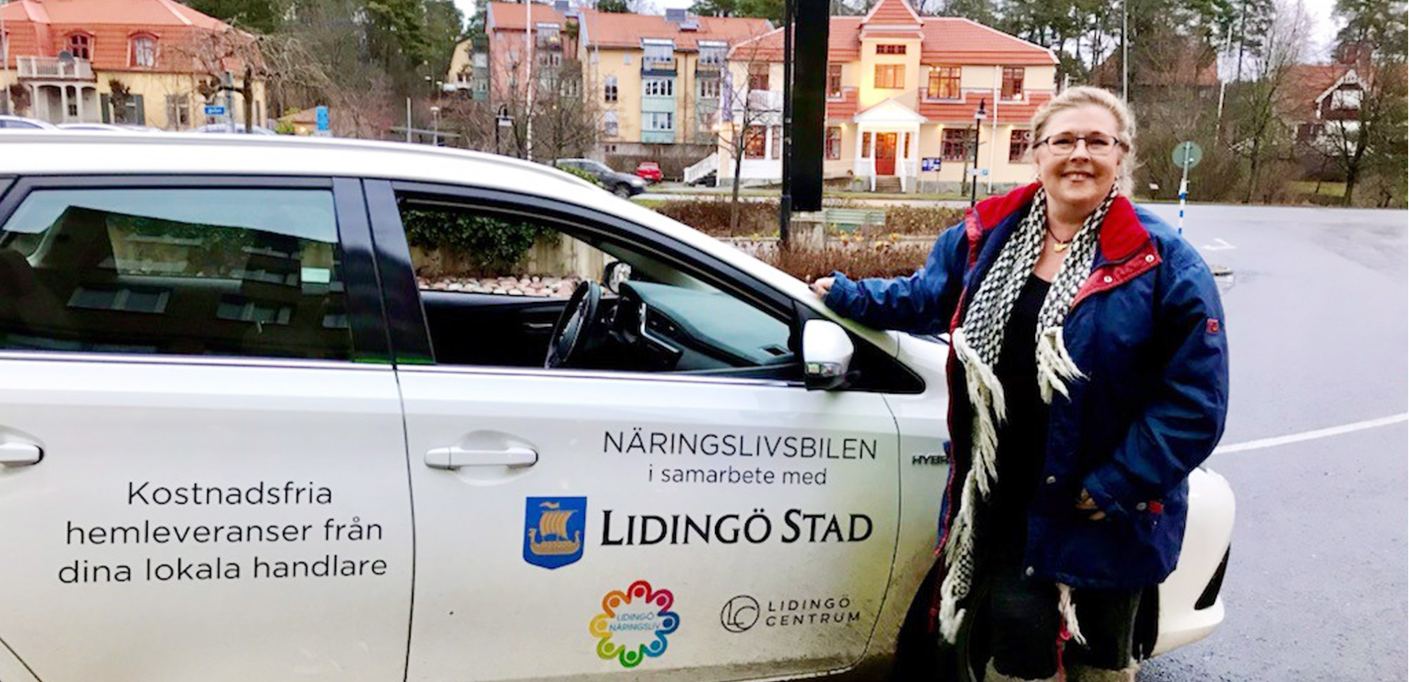 Kille står framför en vit bil i Lidingö centrum.