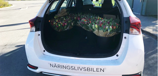 Näringslivsbilen med blommor i öppen bagagelucka