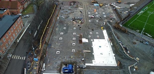 Drönarbild med hus och en byggarbetsplats.