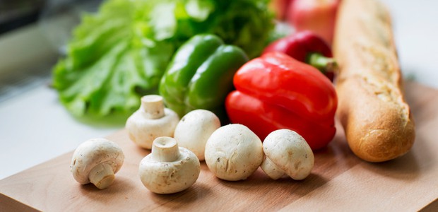 Färska råvaror på en skärbräda (sallad, champinjoner, bröd)
