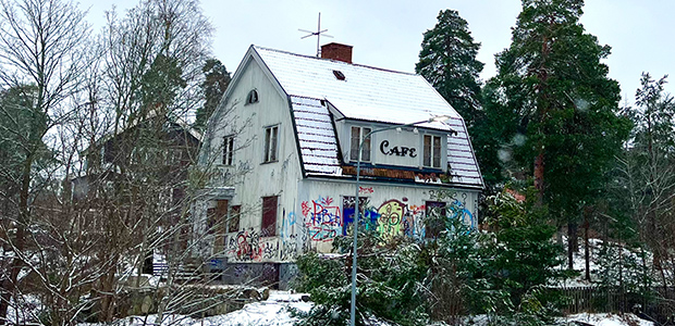 Ett fallfärdigt och nedklottrat vitt hus.