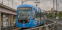 Blå spårvagn som åker över en bro.