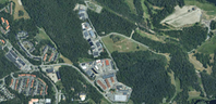 Flygbild över ett området med byggnader och skog runtomkring.